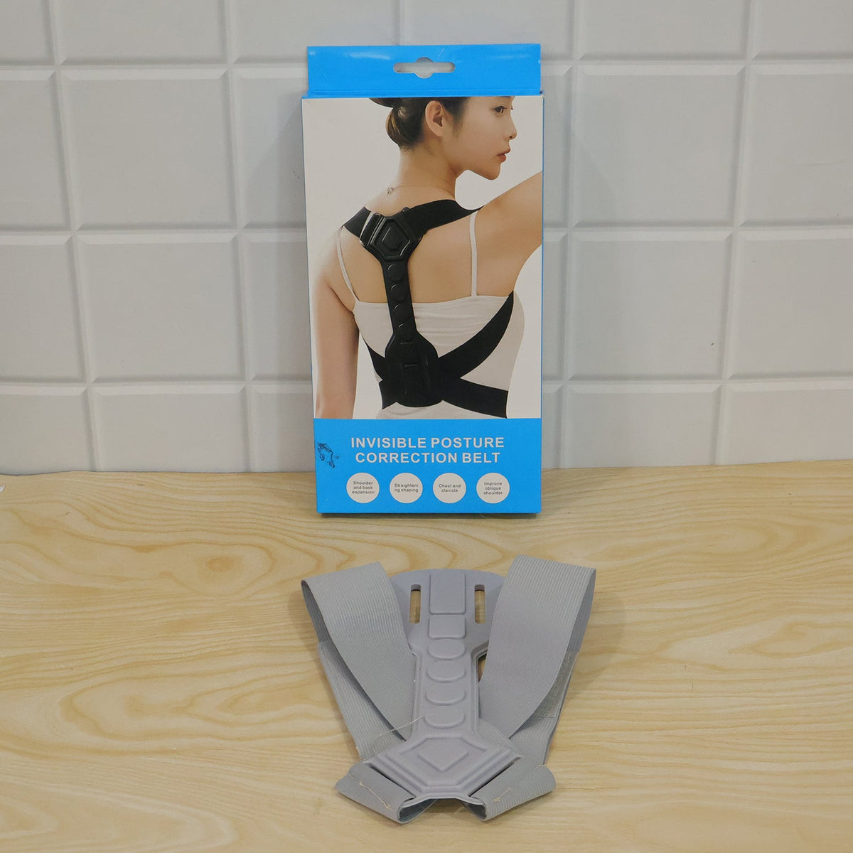 Gray posture corrector in front of its product box